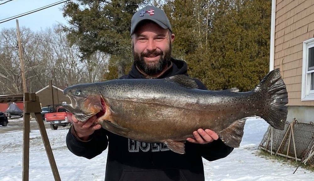 Fisherman finagles record rainbow trout through tiny hole in ice